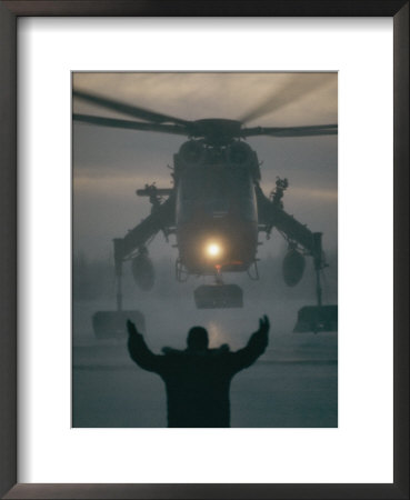 A Man Guides a Landing Helicopter: Framed Art Print